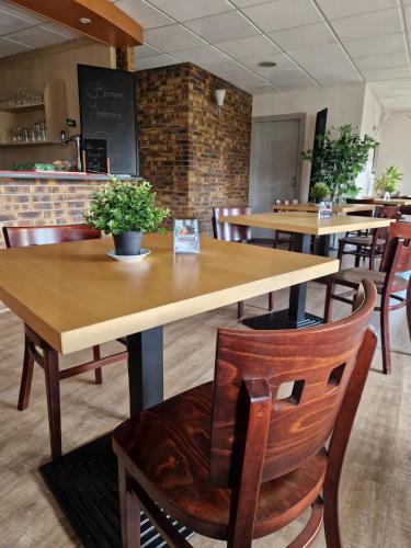 une salle à manger avec des tables et des chaises en bois dans l'établissement Prest'Hôtel Epinal Chavelot, à Épinal