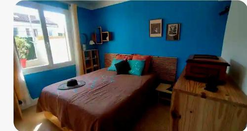 une chambre avec un grand lit avec un mur bleu dans l'établissement Joli T3 La Louvière, à Toulon