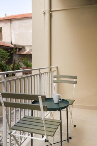 a green table and chair on a balcony at Celine Volos by halu! Cozy apartments in the center in Volos