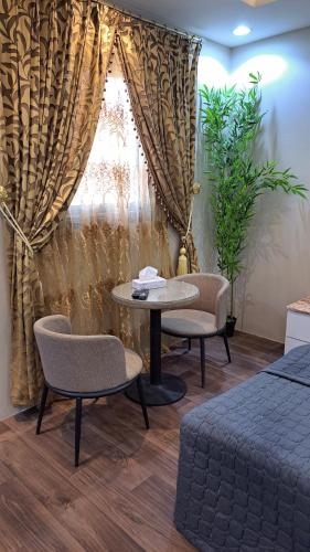 una stanza con un tavolo, due sedie e una finestra di استوديو ريفي تنومة a Tanomah