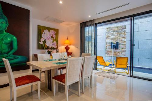 a dining room with a table and chairs at Naiharn Pool Villa Number 5 in Rawai Beach
