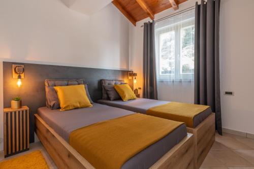 a bedroom with two beds with yellow pillows at Villa Lavanda near Pazin, a modern pool villa in the heart of Istria in Pulići