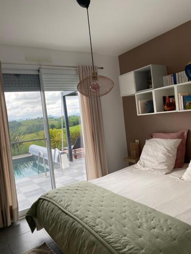 - une chambre avec un lit et une vue sur une terrasse dans l'établissement Entre mer et montagne AMA LUR, à Hasparren