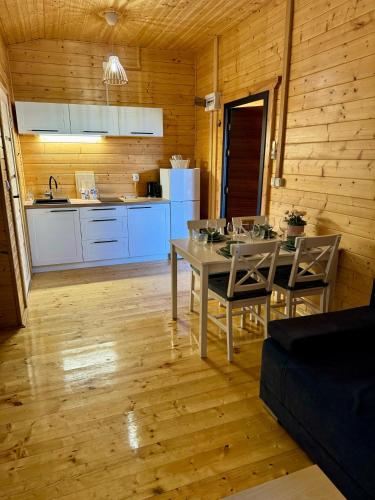 a kitchen and dining room with a table and chairs at Kwiatowy Zakątek in Jantar