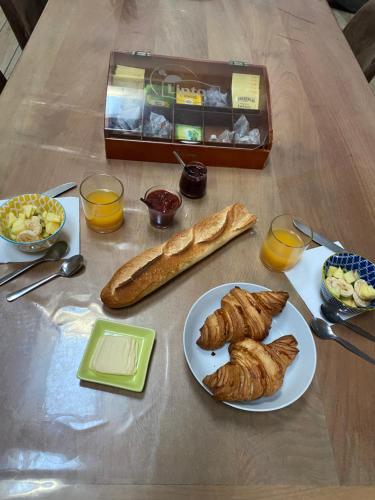 a table with a plate of pastries and a box of bread at LA GRANDE THIBAUDIERE in La Plaine