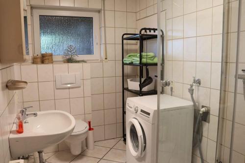 a bathroom with a washing machine and a sink at Ferienwohnung Voege in Schmallenberg
