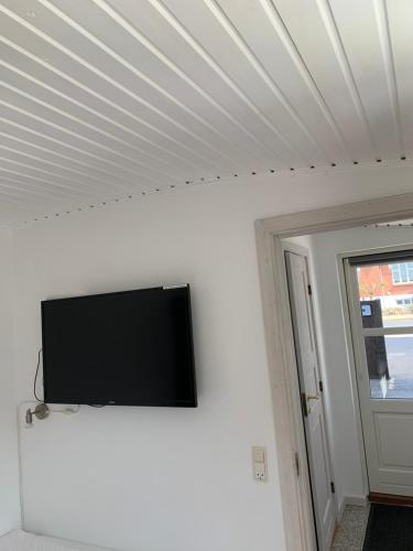 a flat screen tv mounted on a white wall at H C Andersen city apartment in Odense