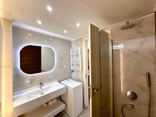 W łazience znajduje się umywalka, lustro i prysznic. w obiekcie Artdeco Luxury Suites w mieście Korakiaí