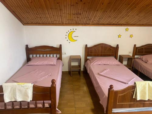 two beds in a room with a moon and stars on the wall at Happy Corner Guest House in Shkodër