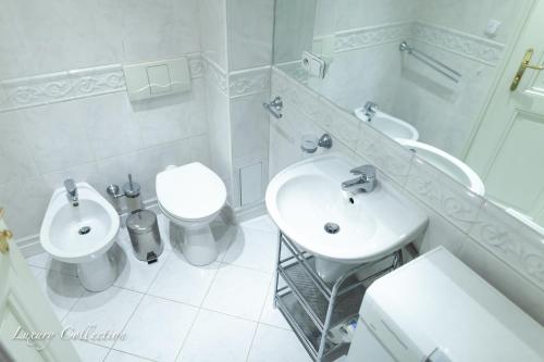 a white bathroom with a sink and a toilet at New Old Town Square Sdudio in Prague