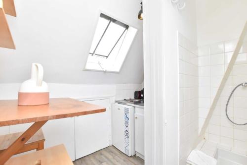 une salle de bain avec un lavabo et des toilettes et une fenêtre dans l'établissement Cosy Studio en plein coeur du 16e arrondissement, à Paris