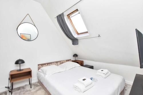 une chambre avec deux lits et un miroir dans l'établissement Cosy Studio en plein coeur du 16e arrondissement, à Paris
