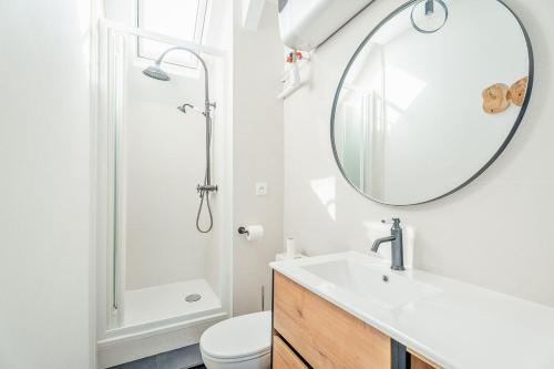 une salle de bain avec un lavabo et un miroir dans l'établissement Emeraude - Superbe t2 lumineux - refait à neuf, à Dinard