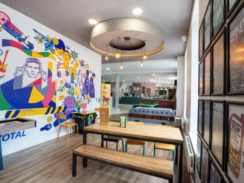 a dining room with a table and a mural at YHA Manchester in Manchester