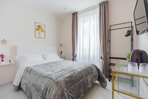 Dormitorio blanco con cama y mesa de cristal en Ginevra Luxury Taormina by Wonderful Italy, en Taormina