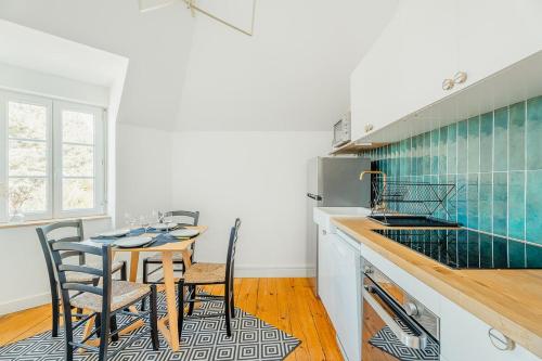 une cuisine avec une table et des chaises dans une pièce dans l'établissement Emeraude - Superbe t2 lumineux - refait à neuf, à Dinard