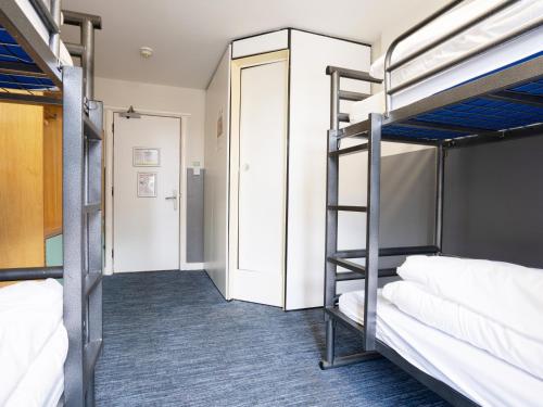 a room with three bunk beds and a hallway at YHA Manchester in Manchester