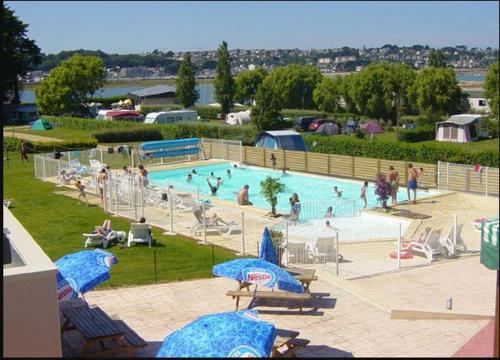 une grande piscine avec des personnes dans un parc dans l'établissement Mobilhome, à Louannec