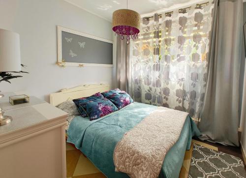 a small bedroom with a bed and a window at MAYA apartament in Jantar