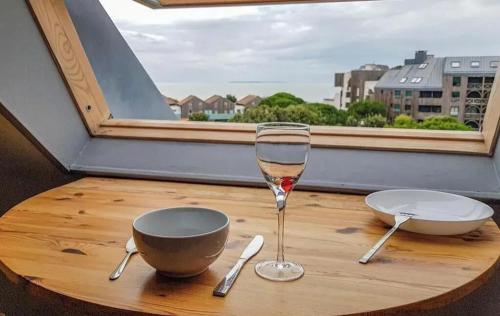 un verre de vin assis sur une table à côté d'une fenêtre dans l'établissement Charmant appartement à La Rochelle 41 m² avec parking, à La Rochelle