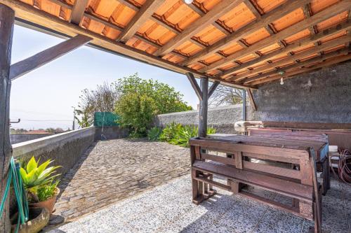 a wooden bench sitting under a wooden pergola at Casa de Campo Serrão in Calheta