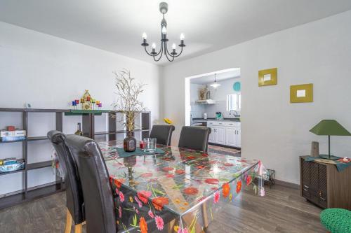 a dining room with a glass table and chairs at Casa de Campo Serrão in Calheta