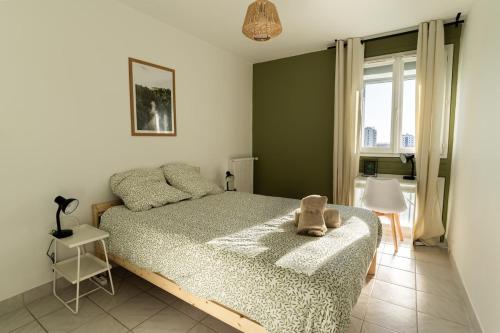 une chambre avec un lit avec un animal en peluche dessus dans l'établissement L'élégant - Parking - Metro, à Toulouse