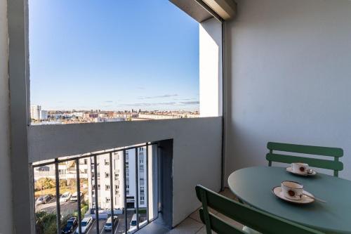 une table et des chaises dans une pièce avec une fenêtre dans l'établissement L'élégant - Parking - Metro, à Toulouse