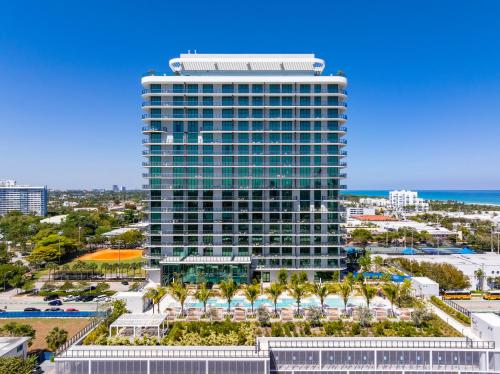 un alto edificio con palme di fronte all'oceano di 72 Park by Nomada Residences a Miami Beach