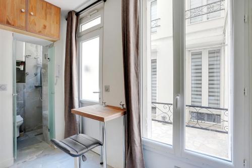 La salle de bains est pourvue d'une table et d'une fenêtre. dans l'établissement Cozy 2P studio Batignolles, à Paris