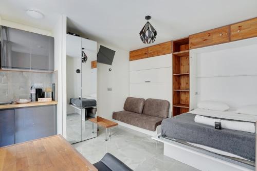 une chambre avec un lit, un canapé et une table dans l'établissement Cozy 2P studio Batignolles, à Paris