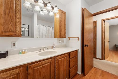 a bathroom with a sink and a mirror at Majestic Escapes Hot Tub Firepit Deck Large Yard in Lake Ann