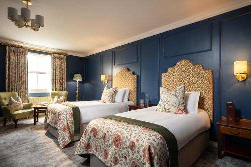 two beds in a room with blue walls at The Harbourview Hotel in Carnlough
