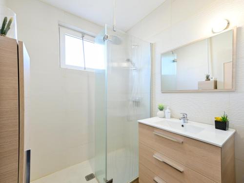 un bagno con lavandino e doccia in vetro di Le Cocon Perché - Ambiance Pastel et Jardin Arboré a Cholet