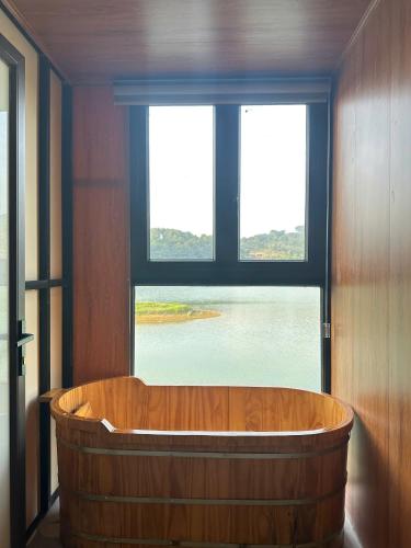 a wooden tub in a room with a large window at NaNa Farm in Bak Kan