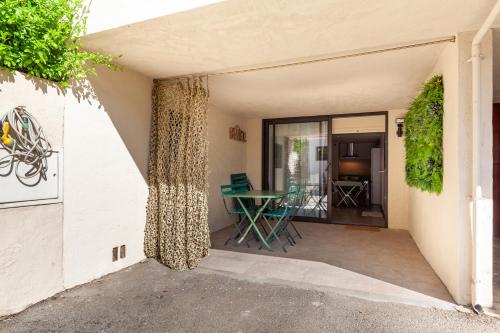 un patio avec une table et des chaises dans un bâtiment dans l'établissement Appartement Hanou de 1 à 4 personne, à Bandol