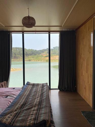 a bedroom with a bed with a view of the water at NaNa Farm in Bak Kan