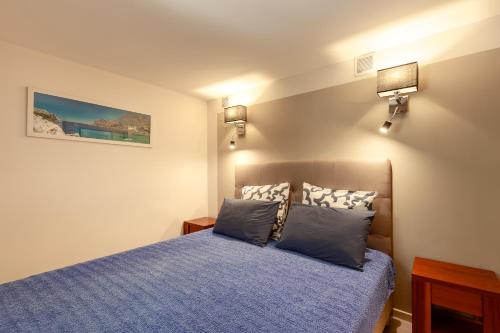 - une chambre avec un lit bleu et 2 oreillers dans l'établissement Appartement Hanou de 1 à 4 personne, à Bandol