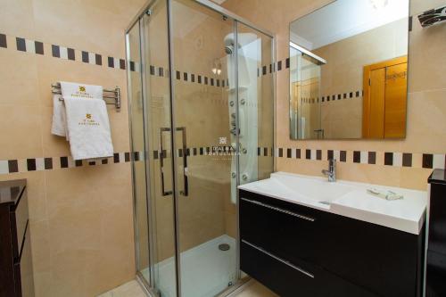 a bathroom with a glass shower and a sink at Apartamento Varandas do Mar in Olhos de Água