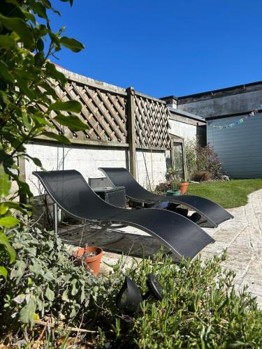 a group of black chairs sitting in a yard at Palm Haven House - Luxury family-friendly Newquay surf house near Porth Beach perfect for walking, pets, exploring in Newquay