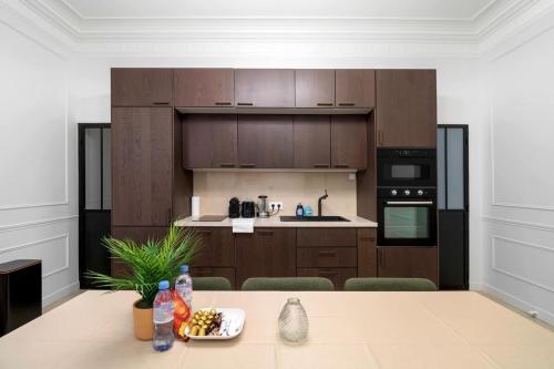 - une cuisine avec des placards en bois et une table avec un bol de nourriture dans l'établissement Apartment 8Pers#4Bedrooms#4Bathrooms#LaFayette, à Paris
