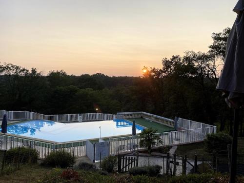une grande piscine entourée d'une clôture. dans l'établissement Villa émeraude, à Cublac
