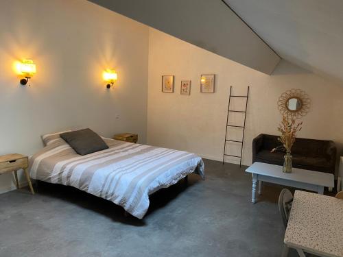 une chambre avec un lit, une chaise et une table dans l'établissement Villa émeraude, à Cublac