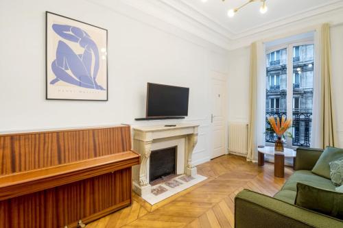 Il comprend un salon doté d'une cheminée et d'une télévision à écran plat. dans l'établissement Apartment 8Pers#4Bedrooms#4Bathrooms#LaFayette, à Paris