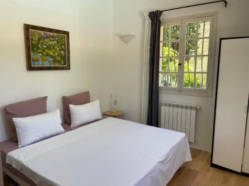 une chambre avec un lit blanc et une fenêtre dans l'établissement Villa Camino with Magnificent pool, à Vence