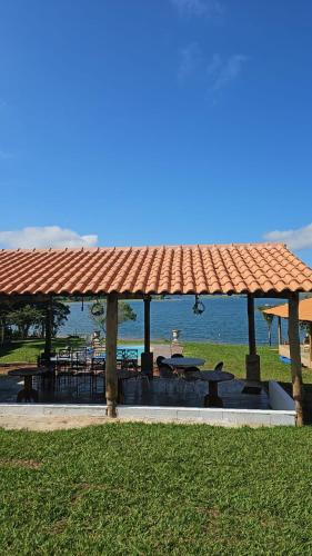 a picnic shelter with tables and a view of the water at Pousada Bella Vista in Delfinópolis