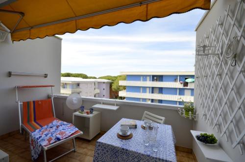 a balcony with a table and chairs and a building at Appartamenti La Quercia in Bibione