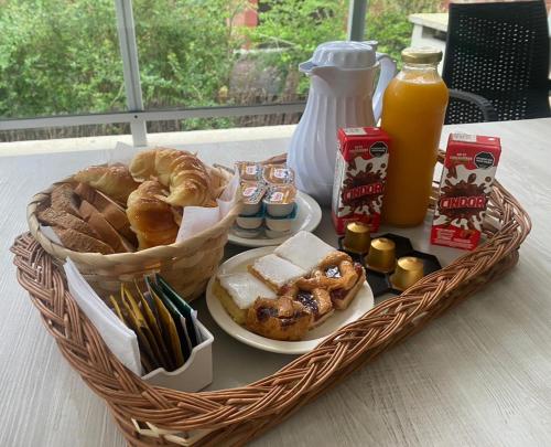 a basket of bread and pastries and a bottle of orange juice at Alley Pampa in Mar de las Pampas