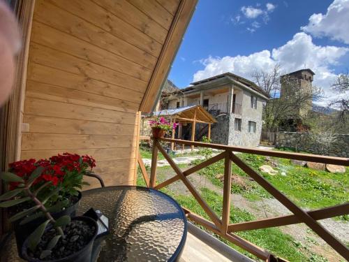 a balcony with a table and flowers and a building at Guesthouse Venera in Mestia