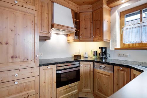 a kitchen with wooden cabinets and black counter tops at Ferienwohnung Huttenberg in Reit im Winkl